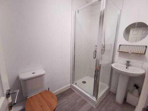 a white bathroom with a shower and a sink at Relax and enjoy the sea view in Kent