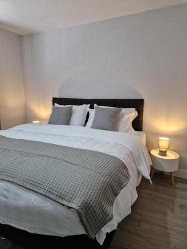 a bedroom with a large white bed with two lamps at Stylish 2 bed home- short walk to Tottenham Stadium/Stations in London
