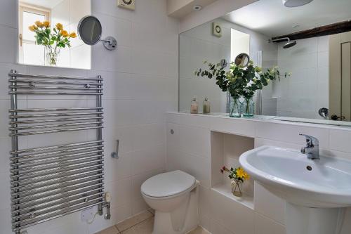a white bathroom with a toilet and a sink at Finest Retreats - Hen Dafarn in Conwy