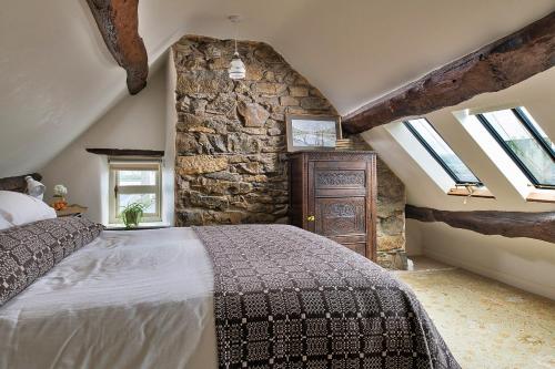 a bedroom with a bed and a stone wall at Finest Retreats - Hen Dafarn in Conwy