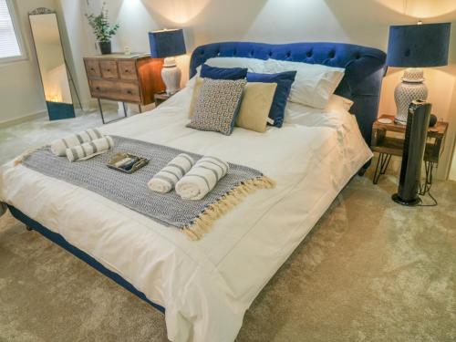 a bed with a blue headboard and pillows on it at Pass the Keys Super Luxurious 2 bedroom Lace Market Apartment in Nottingham
