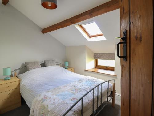 a bedroom with a bed and two windows at 2 Ty Capel in Corwen
