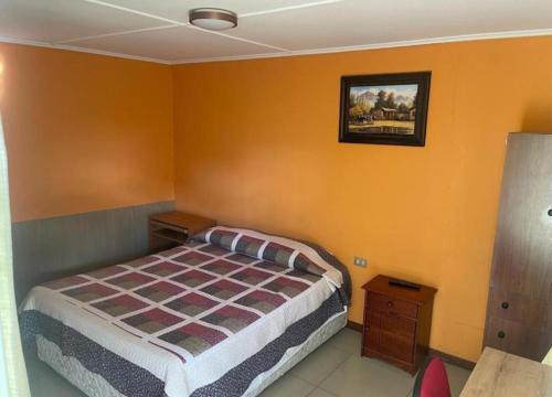 1 dormitorio con 1 cama y una foto en la pared en Hostal Uribe en Calama