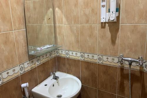 La salle de bains est pourvue d'un lavabo et d'un miroir. dans l'établissement Ketapang Residence Powered Nature, à Jakarta