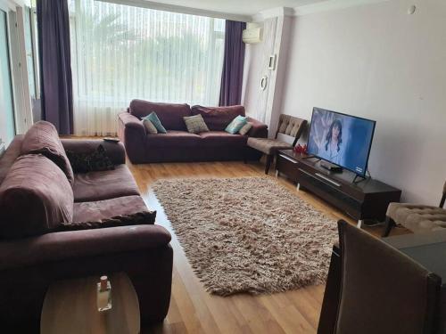 a living room with two couches and a television at Bostanlı Sahile Yakın 2+1 Daire in Karşıyaka