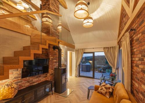 a living room with a fireplace and a brick wall at Lisie Sprawki in Bebło