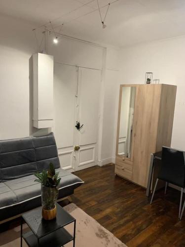 - un salon avec un canapé et une table dans l'établissement Studio chaleureux Paris 20e, à Paris