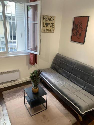 - un salon avec un canapé et une table dans l'établissement Studio chaleureux Paris 20e, à Paris