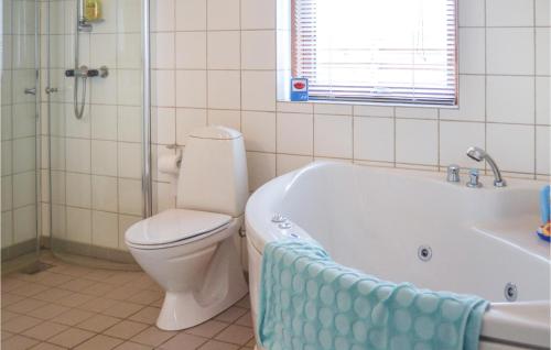 a bathroom with a toilet and a tub and a sink at Nice Home In Vinderup With 4 Bedrooms And Wifi in Vinderup