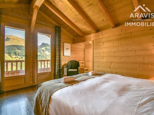 ル・グラン・ボルナンにあるChalet Le Grand-Bornand, 5 pièces, 8 personnes - FR-1-391-8の木製の部屋に大型ベッドが備わるベッドルーム1室が備わります。