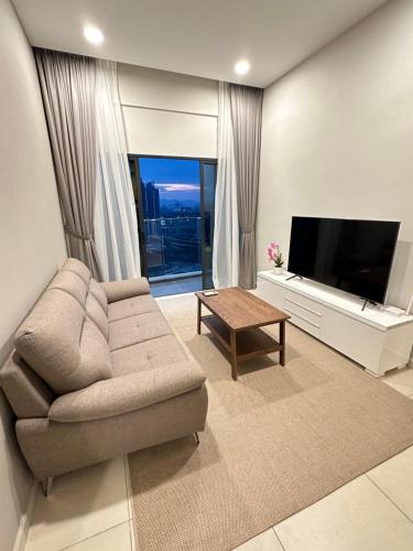 ein Wohnzimmer mit einem Sofa und einem Flachbild-TV in der Unterkunft Reizz Residence By Leo Suites in Kuala Lumpur