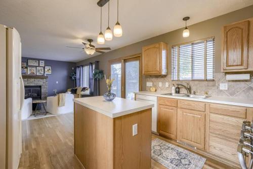 a kitchen with wooden cabinets and a living room at Cozy Winter Retreat with Modern Minimalist Charm in Omaha