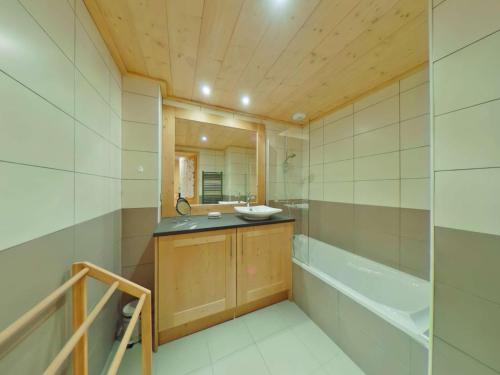 a bathroom with a tub and a sink and a bath tubermott at Appartement Villard-sur-Doron, 4 pièces, 7 personnes - FR-1-594-53 in Villard-sur-Doron