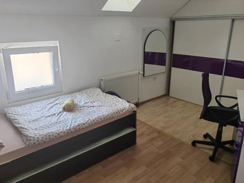 um quarto com uma cama, uma cadeira e uma janela em Kuća Barbara em Slavonski Brod