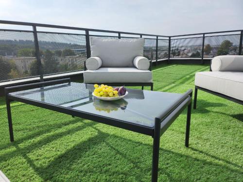 a glass coffee table with a bowl of fruit on a balcony at Best View Terrace in Târgu-Mureş