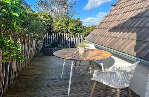 a wooden table and chairs on a wooden deck at Sylter Glanz Kommissar Feldmann in Hörnum