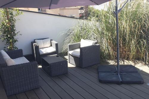 - une terrasse avec des chaises, un parasol et un parasol dans l'établissement Studio neuf indépendant terrasse, à Cannes