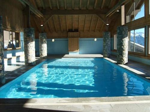 une grande piscine avec de l'eau bleue dans un immeuble dans l'établissement Appartement 3 pièces avec piscine, proche centre Les Saisies, 5 pers, parking, balcon, classé 3 étoiles - FR-1-594-98, à Villard-sur-Doron