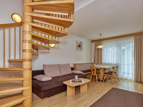 a living room with a couch and a spiral staircase at Apart Albert in Ischgl