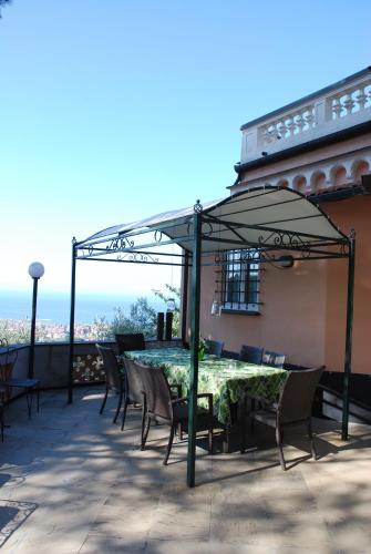 a table and chairs under an umbrella on a patio at Villa Rocca Leivi in Leivi