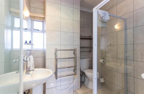 a bathroom with a sink and a toilet and a shower at Mouille Point Apartments in Cape Town