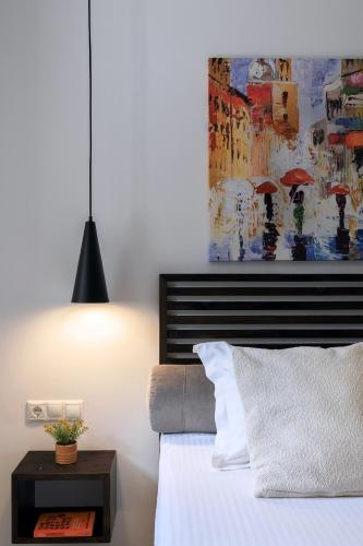 a bedroom with a bed and a painting with umbrellas at Blue Sky House in Pylos