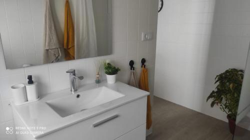 een badkamer met een witte wastafel en een spiegel bij Casa Tia Pilar in Algodonales