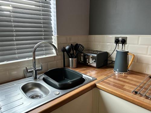 a kitchen counter with a sink and a microwave at Spacious 3 bed house in Wombwell in Wombwell