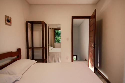a bedroom with a bed and a large mirror at Villa Botanic Garden in Itacaré