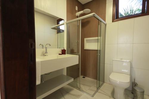 a bathroom with a toilet and a sink and a shower at Villa Botanic Garden in Itacaré
