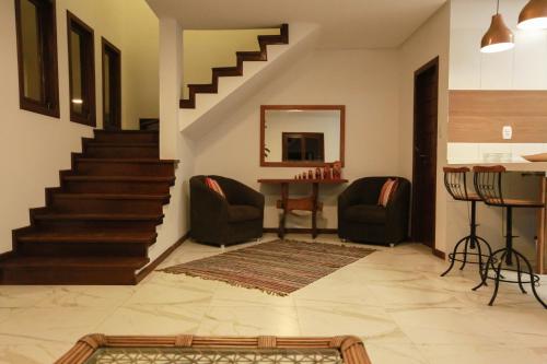 a living room with stairs and chairs and a table at Villa Botanic Garden in Itacaré