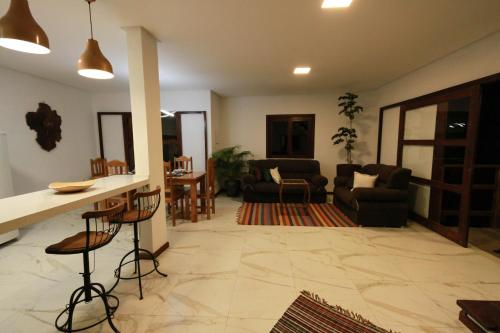 a living room with a kitchen and a living room with a bar at Villa Botanic Garden in Itacaré
