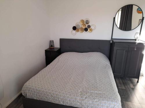 une chambre avec un lit et un miroir dans l'établissement Studio type T1 avec parking et cave à 600 m de la plage, à Fréjus