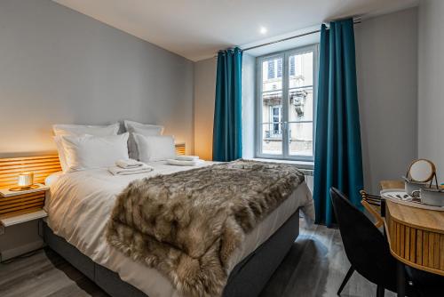 een slaapkamer met een bed, een bureau en een raam bij Aux Fleurs de Darcy Confort Centre Ville in Dijon