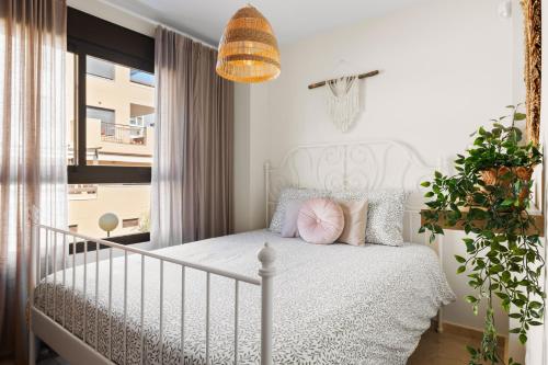 - une chambre avec un lit blanc et des oreillers roses dans l'établissement Casa Tajo, à La Cala de Mijas