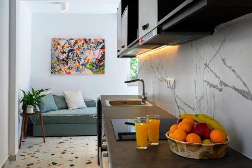 a kitchen with a bowl of fruit and glasses of orange juice at Blue Sky House in Pylos