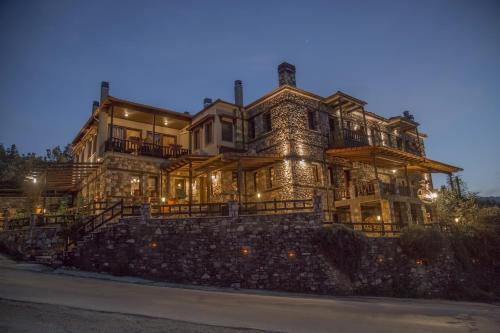 a large house on a stone wall at night at Pandion Luxury Boutique Hotel & Suites with Spa in Neochori