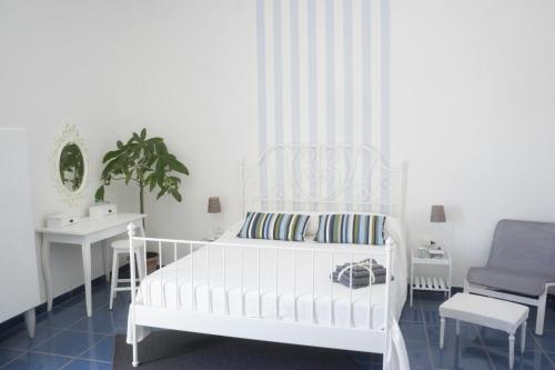 ein weißes Schlafzimmer mit einem weißen Bett und einem Stuhl in der Unterkunft Taggarb in Neapel
