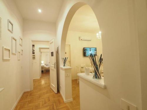 un pasillo con un arco en una casa con TV en VATICAN CITY 76 Apartments, en Roma