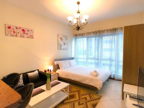 um quarto com uma cama e um lustre em StoneTree - Prime Location - Furnished Studio - Near Metro em Dubai