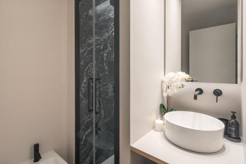 een badkamer met een witte wastafel en een spiegel bij Monti Design Apartment R&R in Milaan