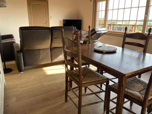 a living room with a table and chairs and a couch at Le Sommelet in Somme-Leuze