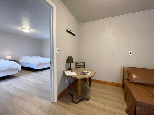 a room with two beds and a table and a mirror at Star Gate Motel in Indian River