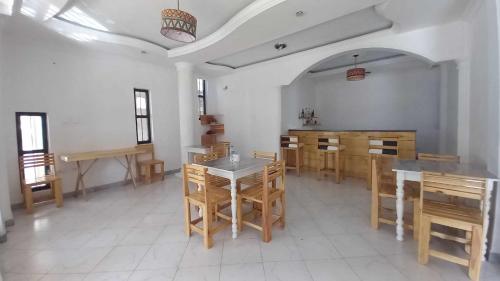 jadalnia z drewnianymi stołami i krzesłami w obiekcie Zanzibar Guest House and Restaurant w Auasie