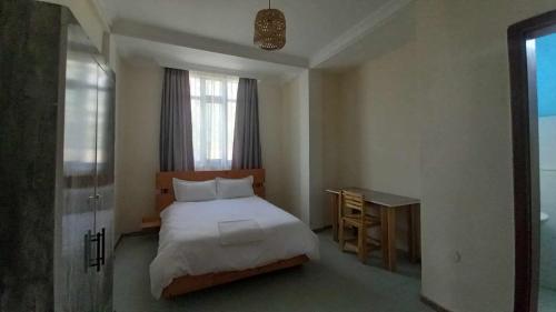 1 dormitorio con cama, escritorio y ventana en Zanzibar Guest House and Restaurant, en Āwasa