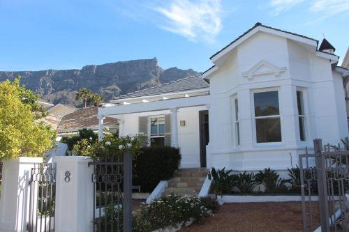 a white house with mountains in the background at Gardens Retreat in Cape Town