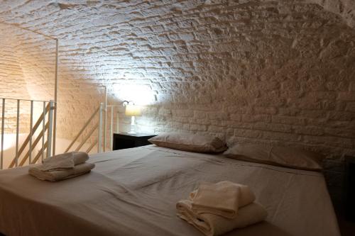- une chambre avec un lit et des serviettes dans l'établissement DOMUS PRAETORIA, à Alberobello