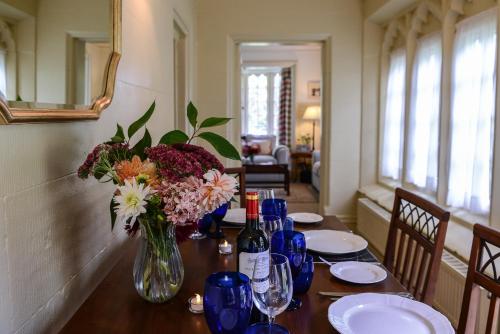 ナントウィッチにあるStone Lodge at Combermere Abbeyの花瓶とワインボトルを用意したテーブル
