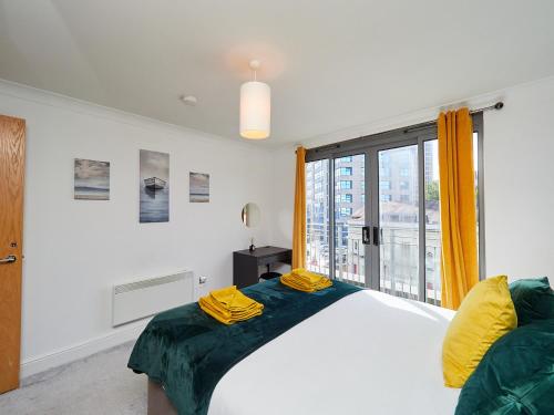 a bedroom with a bed and a large window at Emerald Suite - Two Story Duplex Apartment - Contractors - Family - Business - City Centre - Sleeps 6 in Birmingham