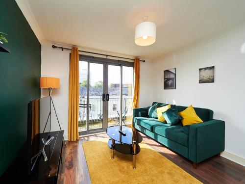 a living room with a green couch and a window at Cosy Emerald Suite - Two Story Duplex Apartment - Balcony - Contractors - Family - City Centre - Broadway Plaza - Five Ways - Sleeps 6 in Birmingham